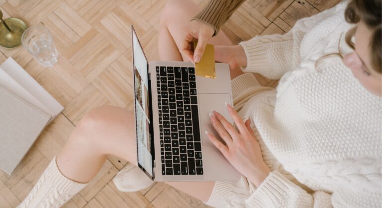 woman shopping online, cream knit clothing, credit card at the ready